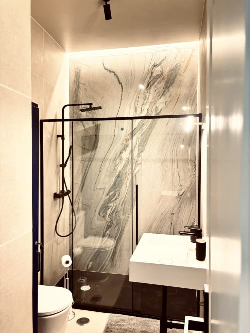 Modern bathroom in Royal Prince Garden Apartments, Lisbon, with marble shower wall, black fixtures, and LED lighting