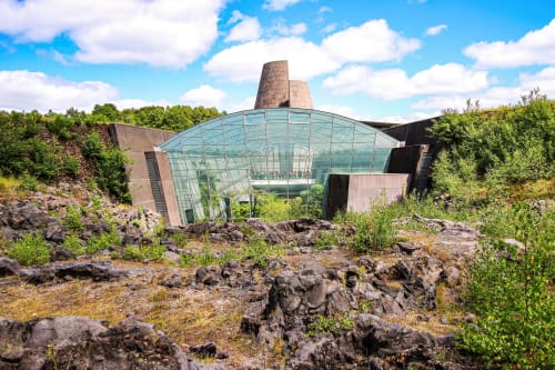 La Caravelle hotel in Riom, France - modern glass structure built into volcanic rock quarry with green landscape