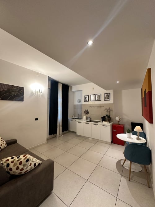 Moderno monolocale a Le Arche Verona con cucina, salotto con divano, tavolo da pranzo e elettrodomestici