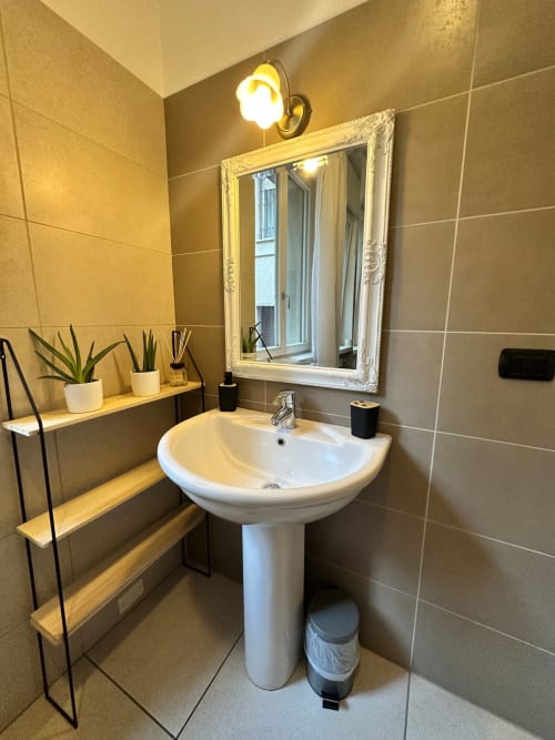 Bagno moderno presso l'Il Tenore B&B Turandot di Verona con lavabo a colonna, specchio incorniciato bianco e ripiani decorativi