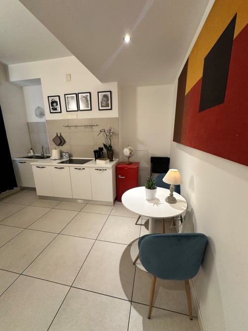 Cucina e zona pranzo moderne presso l'appartamento Le Arche a Verona con arredamenti bianchi, frigorifero rosso e stile contemporaneo