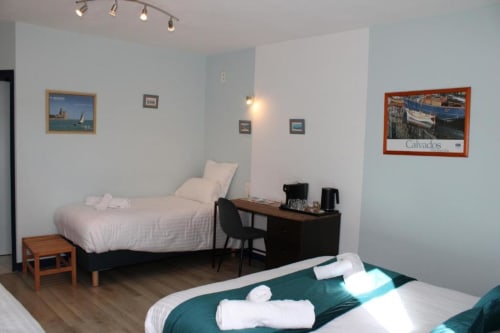 Spacious quadruple room at Domaine des Piéris in Grandcamp-Maisy with twin beds, work desk, and coastal-themed decor