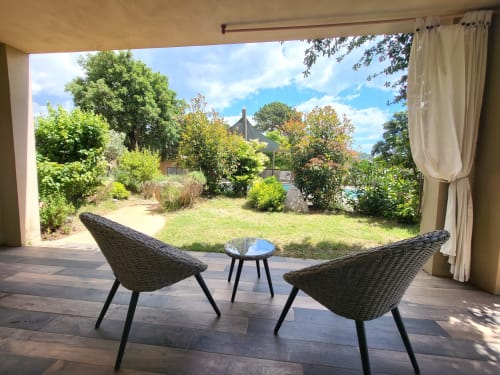 Outdoor lounge area at Villas Lantana with wicker chairs overlooking garden in Lecci