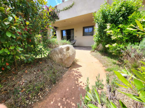 Lush garden pathway leading to modern studio villa at Villas Lantana, Lecci with landscaping and patio