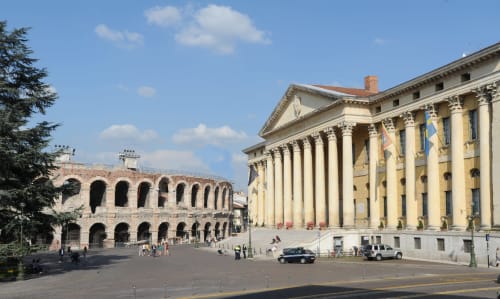 Piazza storica di Verona con antico anfiteatro romano e edificio neoclassico con colonne
