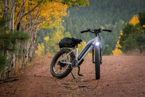 E-bike parked on autumn trail near La Cascina di Bea, Torre Boldone, Bergamo, surrounded by golden birch trees