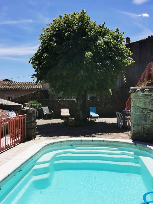 Piscina turchese con grande albero e lettini presso Chambre d'hôtes Gîte Le Tilleul, un bed and breakfast francese con