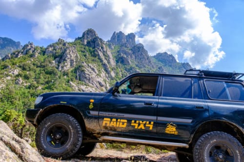 Veicolo 4x4 blu parcheggiato su terreno montuoso roccioso con spettacolari picchi sullo sfondo vicino a Villas Lantana, Lecci