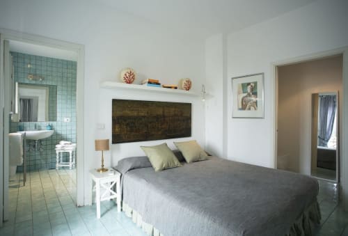 Camera moderna di La Conciergerie Capri con letto grigio, bagno in camera e dettagli in piastrelle verdi
