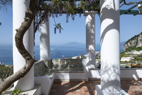 Terrazza di La Conciergerie Capri con vista mare, glicine, colonne bianche e Vesuvio in lontananza