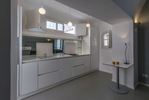 Cucina moderna bianca con luci a sospensione e design minimalista nella camera dell'hotel La Conciergerie Capri a Capri, Italia