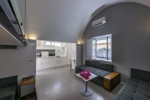 Camera vista mare moderna presso La Conciergerie Capri con cucina open-plan, sedute nere e soffitto ad arco