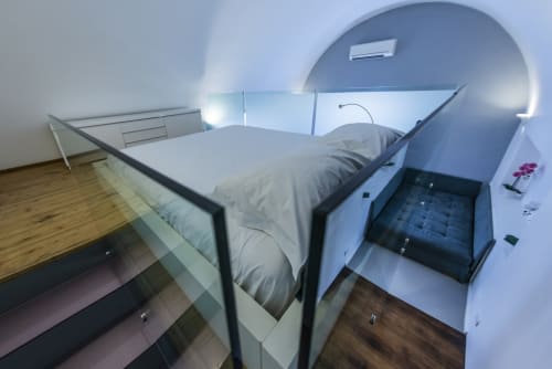 Camera con pod letto compatti a La Conciergerie Capri: design moderno, finiture in legno e luminosa.