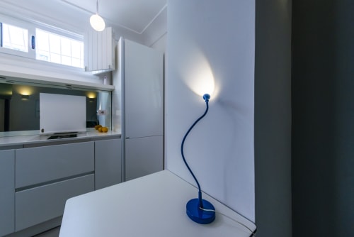 Cucina moderna nella camera dell'hotel La Conciergerie Capri con lampada da tavolo blu flessibile