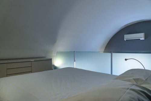 Camera da letto moderna con vista mare a La Conciergerie Capri, design minimalista, soffitto curvo e aria condizionata
