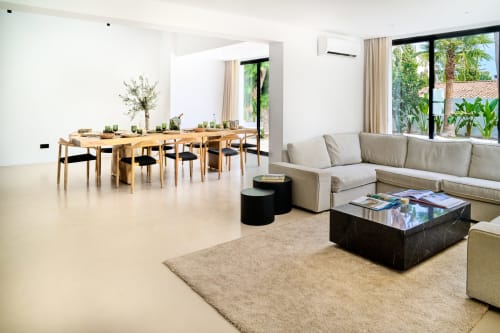 Spazioso living con zona pranzo a pianta aperta a La Conciergerie Capri, tavolo in legno, divano beige e vista sul giardino