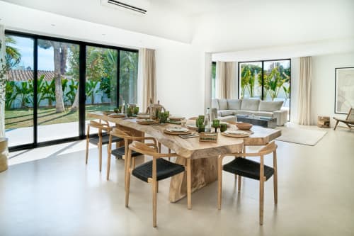 Elegante zona dining a La Conciergerie Capri con tavolo in legno, luce naturale e vista sul giardino