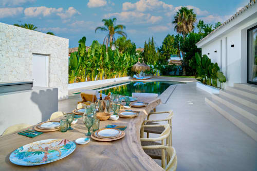 Elegante tavolo in stile all'aperto con vista piscina e mare, circondato da giardini tropicali a La Conciergerie Capri