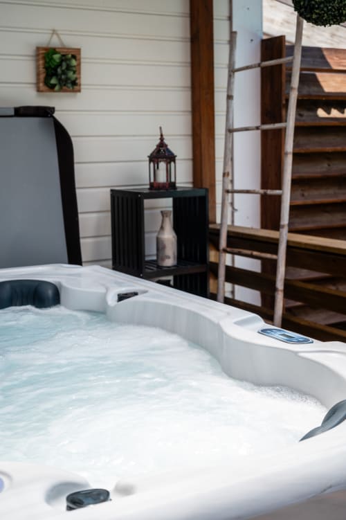 Bain à remous avec eau bouillonnante à la Villa Eden Bleu à Biscarrosse, espace spa extérieur