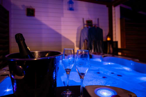 Élégante mise en place de champagne à la Villa Eden Bleu avec deux flûtes, seau à glaçons et ambiance lumineuse bleue à Biscarrosse