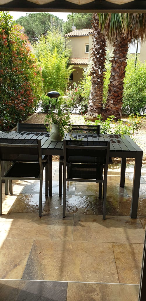 Cap creus-Coin repas avec vue sur jardin arboré et fleuri, Petit barbecue au charbon, jardin avec du gravier rond 