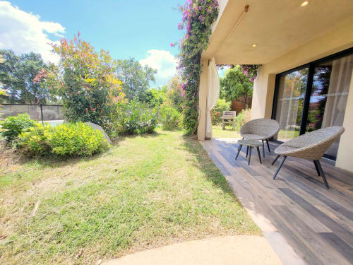 Terrazza Villas Lantana a Lecci con vista giardino, sedie in vimini e viti fiorite sopra
