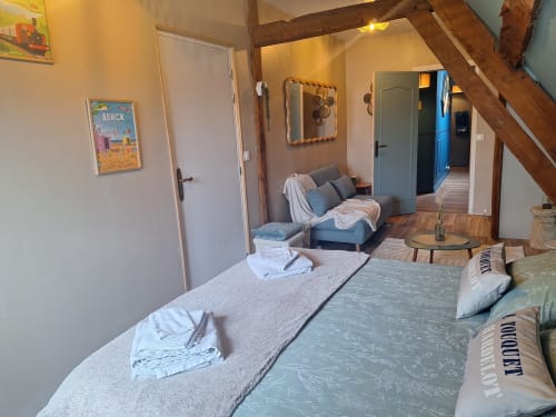 Chambre spacieuse à La Cour d'Hortense B&B à Sailly-Flibeaucourt avec lits jumeaux, coin salon et poutres en bois rustique