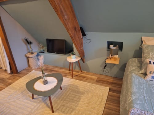 Chambre mansardée douillette à La Cour d'Hortense avec poutres apparentes, télévision, coin salon et vue sur le jardin à Sailly-Flibeaucourt