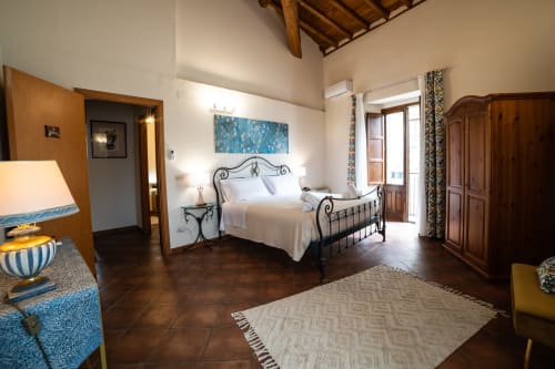 Spaziosa camera da letto a Casa Fiore del Borgo a Castiglione di Sicilia con letto in ferro battuto e vista sulla città