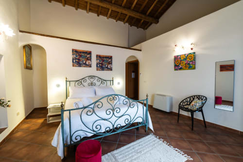 Ampia camera da letto a Casa Fiore del Borgo a Castiglione di Sicilia con eleganti letti in ferro battuto e vista sulla città