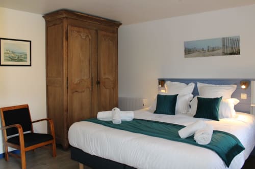 Comfortable double bedroom at Domaine des Piéris in Grandcamp-Maisy with garden view, wooden wardrobe, and modern amenities