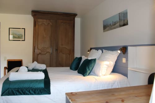 Comfortable double bedroom at Domaine des Piéris B&B in Grandcamp-Maisy with garden view, featuring two beds, wooden