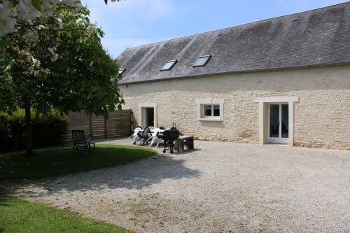 Stone cottage with gravel courtyard at Domaine des Piéris, Grandcamp-Maisy, featuring garden seating area and private