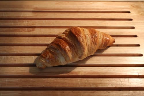 Croissant frais sur des lames de bois à la Domaine des Piéris, gîte de Grandcamp-Maisy, France