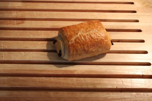 Croissant frais sorti du four sur lattes en bois au gîte Domaine des Piéris à Grandcamp-Maisy, France