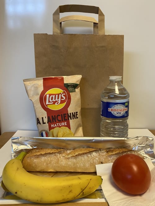 Panier de bienvenue au Domaine des Piérs avec pain français, banane, tomate, chips Lay's et eau Cristaline