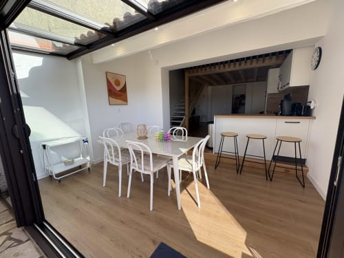 Salle à manger moderne avec chaises blanches et cuisine de la villa Mazet Cavalaire, Cavalaire-sur-Mer
