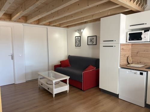 Villa contemporaine au Mazet Cavalaire avec canapé noir, kitchenette, poutres apparentes et mobilier blanc à Cavalaire-sur-Mer