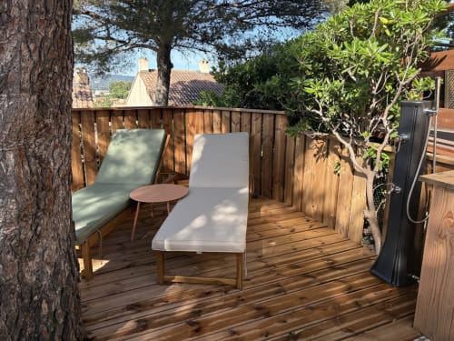 Terrasse en bois avec transats, petite table et vue sur la mer à la villa Mazet Cavalaire à Cavalaire-sur-Mer