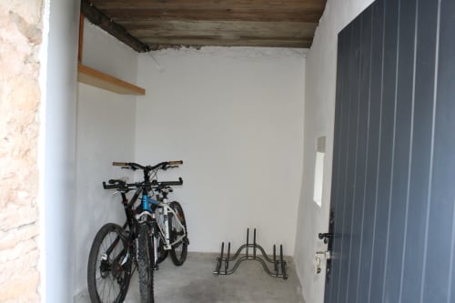 Abri à vélos au Domaine des Piéris avec vélo et rangement métallique sur sol bétonné, Grandcamp-Maisy