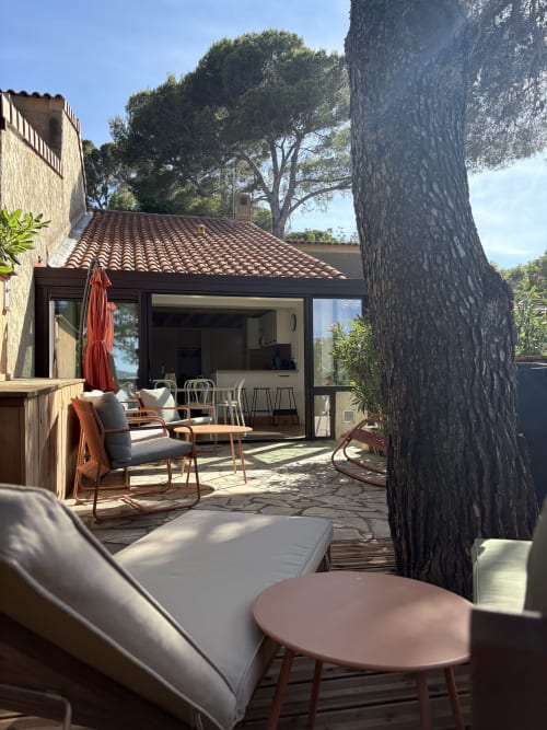 Patio du Mazet Cavalaire avec chaises longues, coin repas et grand arbre à Cavalaire-sur-Mer