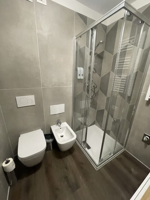 Bagno moderno nell'appartamento di Varenna con doccia, wc, bidet e piastrelle grigie