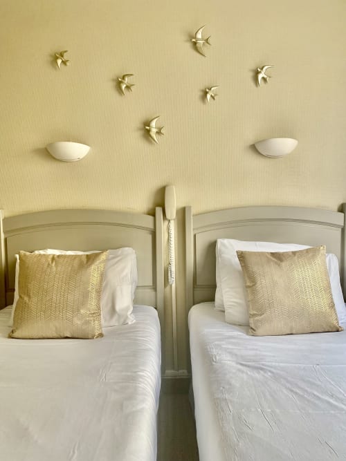 Twin beds with gold pillows and wall decor birds at Hôtel Maison Richet family room, Les Sables-d'Olonne