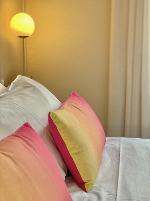 Colorful pillows on bed at Hôtel Maison Richet, Les Sables-d'Olonne cottage room with warm lighting