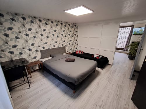 Chambre moderne NancyRoom B&B à Vandoeuvre-les-Nancy : papier peint à motifs, lit queen-size, bureau et vue sur la ville