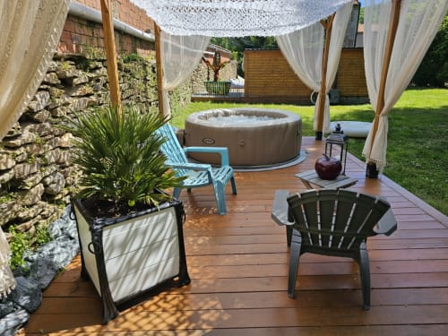 Oasis de jardin à la Bastide du Thoré avec bain à remous, chaises longues et pergola ombragée à Labastide-Rouairoux