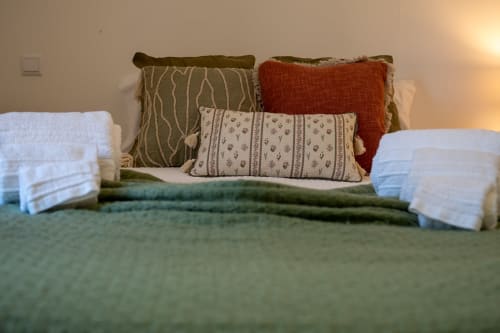 Comfortable bed with decorative pillows and white towels at Corvatos Casas do Monte villa in Almodôvar