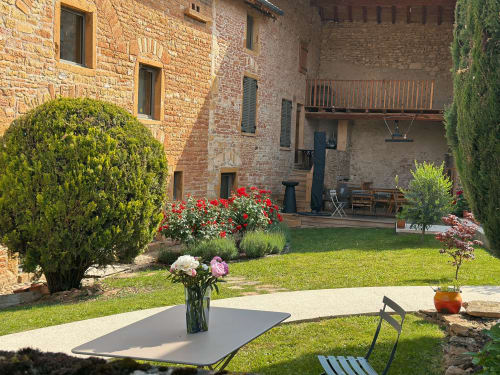 vue vers la terrasse abritée, rosiers en fleurs, maison de pagneux, chambres d'hôtes en Beaujolais des Pierres dorées