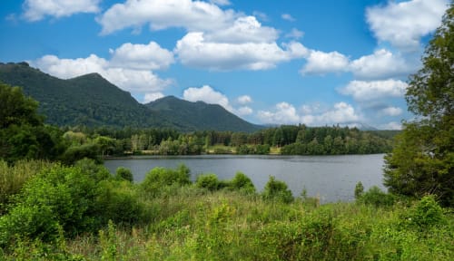 Malerische Bergseenlandschaft mit grünen Wäldern und blauem Himmel nahe Lourdes, Frankreich