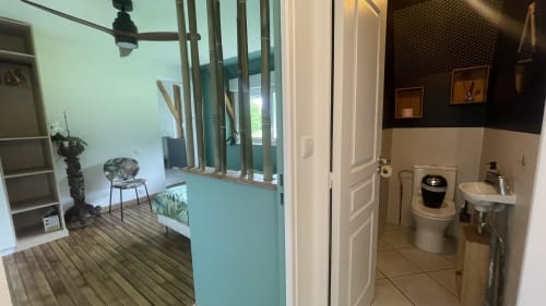 Intérieur de gîte aux murs turquoise, espace de vie ouvert et salle de bain, Conciergerie Pour Tous, forêts de Corrèze